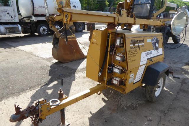 Allmand Night Lite Pro portable light tower/trailer with yellow frame, mounted on a trailer, showing control box and wheel. Text includes Allmand NIGHT-LITE PRO and various labels.