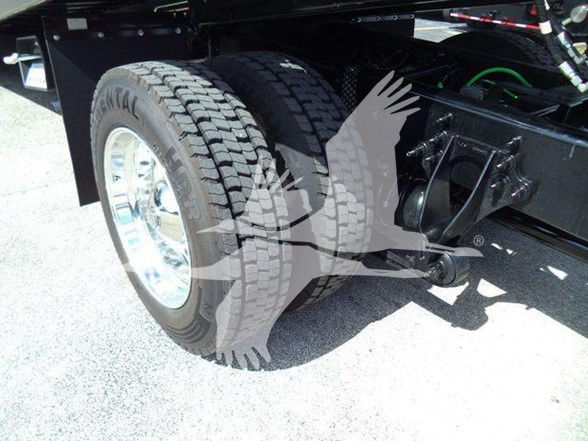 Truck rear wheel and chassis showing dual tires and suspension components.