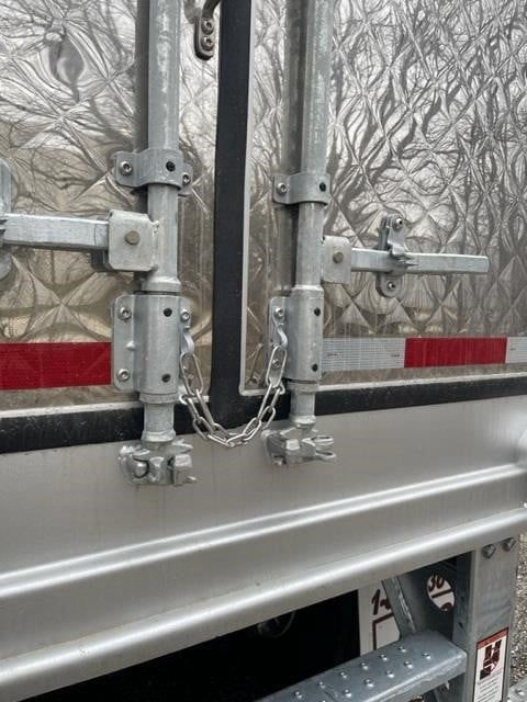 Rear doors of a Cimc Cool Globe reefer trailer with metal latches, chains, and reflective strip; visible text includes no legible labels.