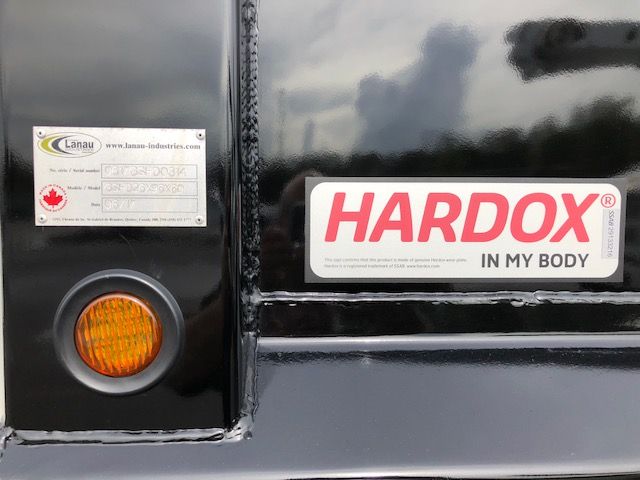 Truck rear showing Hardox in my body sticker and a small metal plate on the left with Canadian flag.