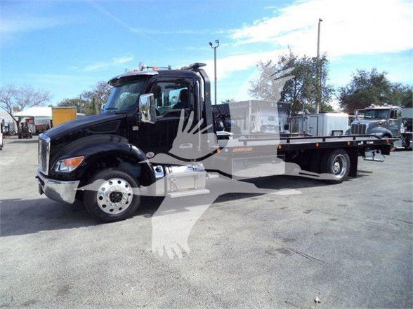 Kenworth T280 tow truck in black, side profile showing flatbed, chrome wheels, and cab with mirrors.