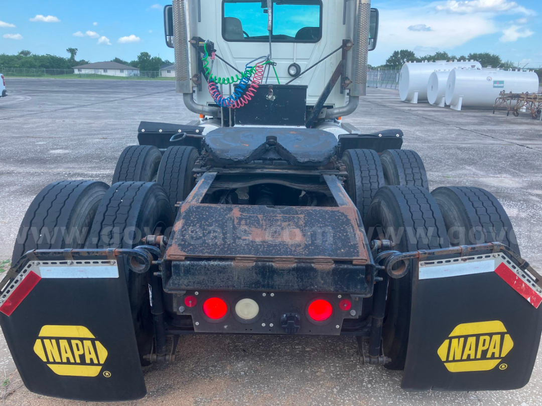 Rear view of a 2006 Mack CHN613 cab and chassis showing rusted frame and dual rear axle configuration with NAPA mud flaps, taillights, and wiring harnesses.