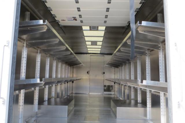 Ford F59 step van interior cargo area with metal shelving and ribbed walls.