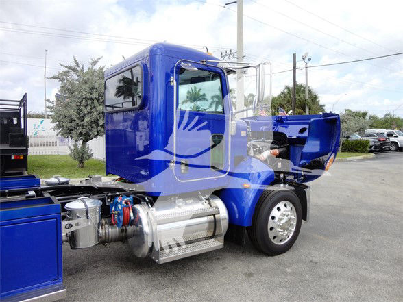 Blue 2022 Peterbilt 337 truck cab and engine area visible with hood open, chrome air filter, and fuel tanks.