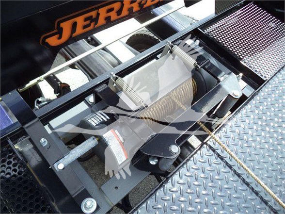 Tow truck bed winch assembly with cables and springs visible on diamond plate platform.