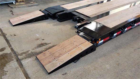 Fontaine lowboy trailer deck sections with wooden ramps and metal frames, showing lowboy configuration and support ramps.