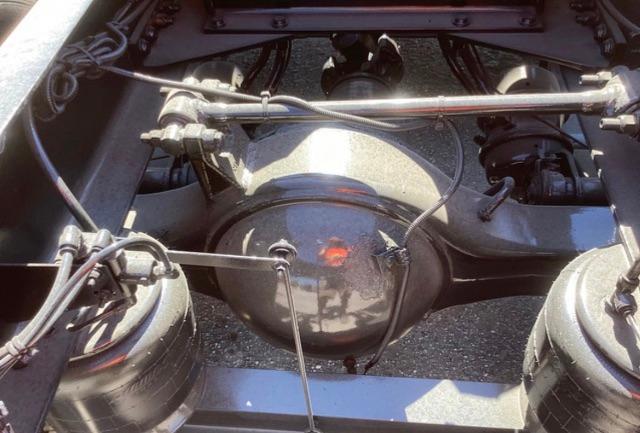 Rear view of Peterbilt 579 chassis showing air brake system and differential housing with surrounding suspension components.