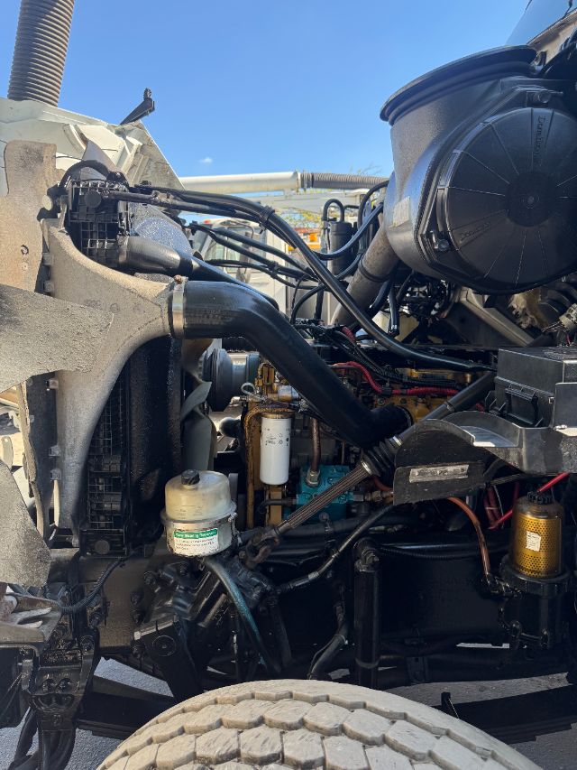 Sterling L8500 truck engine bay showing coolant reservoir, filter, hoses, and various engine components.