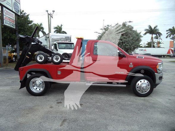 Ram 4500 tow truck with a winch bed in red, extended cab, white wheels, visible Ram badge and RAM lettering on the side.
