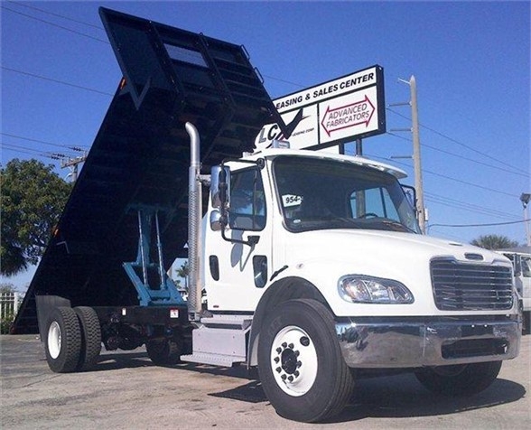 Flatbed dump truck with raised bed, white cab, Advanced Fabricators logo on sign in background, stock number 20FB96. Truck body only - flatbed, new condition.