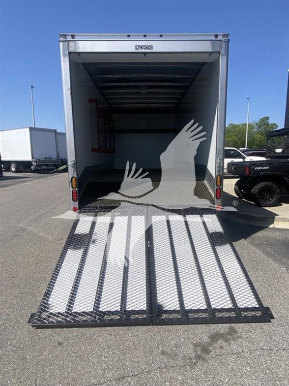Isuzu NPR HD box truck with rear ramp lowered, interior cargo area visible, loading ramp grated metal with diamond pattern.