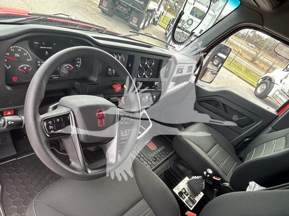 Cab interior of a 2026 Kenworth T480 dump truck showing steering wheel, dashboard gauges, center console, and driver seat.