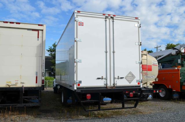 Kenworth T370 box truck rear view showing white cargo box with double barn doors and reflective markers.