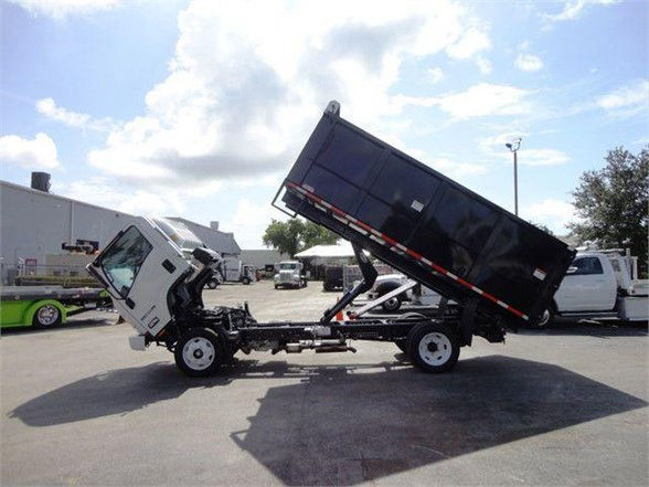 Isuzu NPR HD dump truck with tipped-bed in a dealership lot