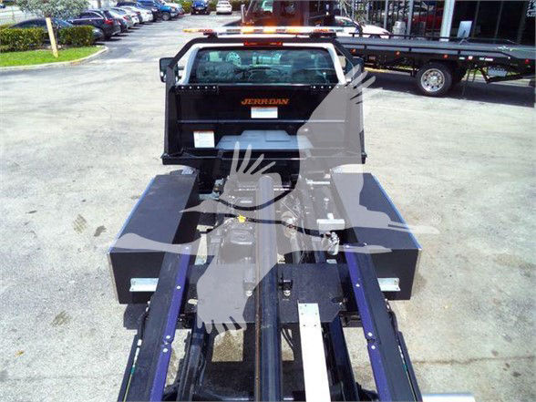 Front view of a 2023 Chevrolet Silverado 6500HD tow truck bed with a black Pearl tank and purple rails, showing the rear chassis and hydraulic/tow equipment.