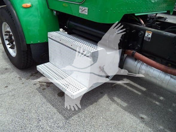 Peterbilt 348 truck with a metal aluminum side step/footboard attached to the chassis; visible exhaust pipe and green cab.