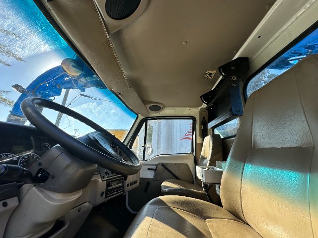 Sterling vacuum truck cabin interior showing steering wheel, dashboard, two front seats, and overhead equipment mount.