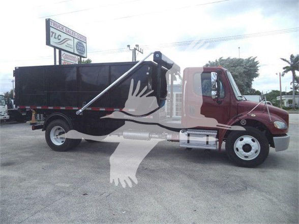 Freightliner BUSINESS CLASS M2 106 dump truck side view with black dump body and maroon cab. visible text on sign in background and truck window reflections.