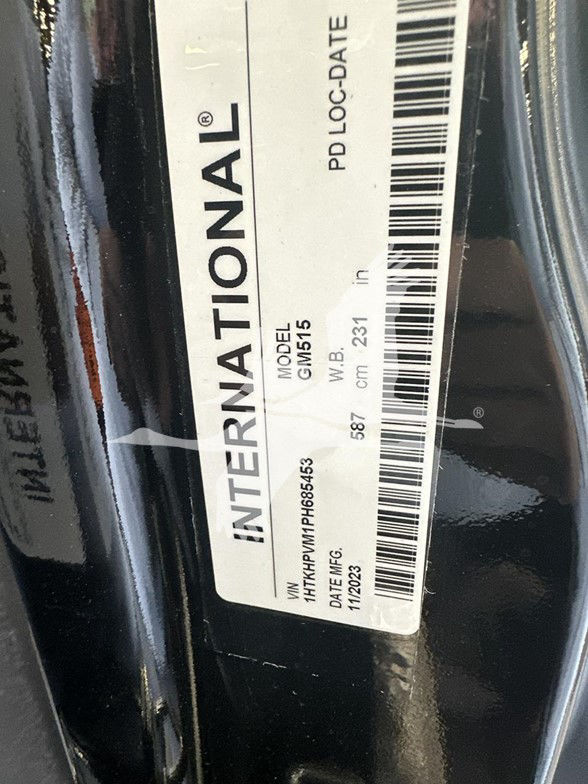 International label on a vehicle door jamb showing MODEL GM515, VIN 1HTKHPVM1PH685453, PD-LOC-DATE, 587 cm, date 11/02/03.