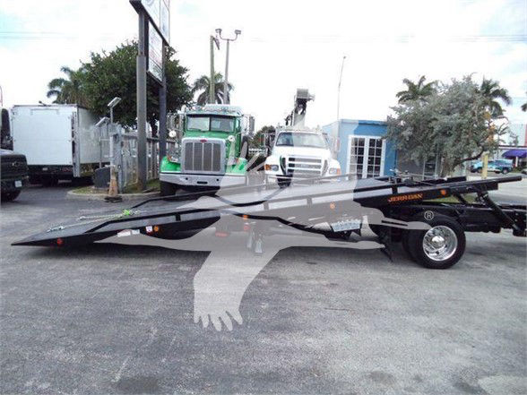 Tow truck with a low-profile car hauler trailer. Visible text includes 'HERCULES' on the trailer and several reflective safety markings. No engine or fluid labels clearly legible.