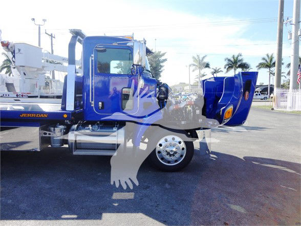 Truck cab side of blue Peterbilt 337 with open hood and chrome fuel tank visible.