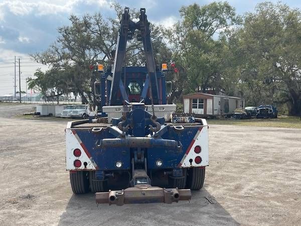 Peterbilt 359 tow truck rear view showing hitch, hydraulics, dual rear axles, and reflective chevron panels.