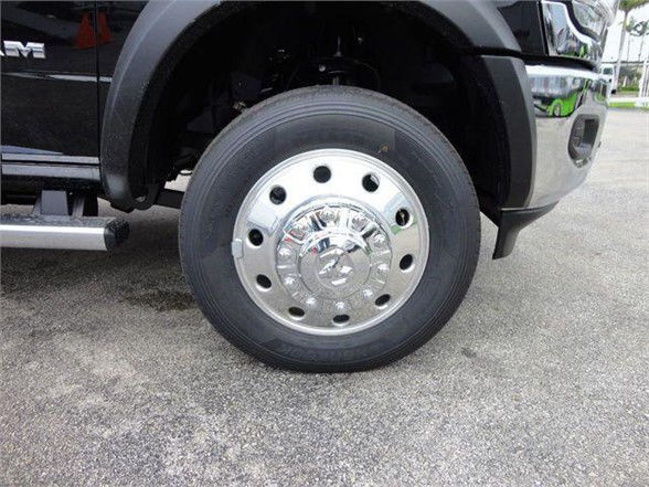 Front wheel of a 2024 Ram 4500 SLT showing chrome hubcap and tire The image focuses on the wheel area with a portion of the truck fender and bumper.