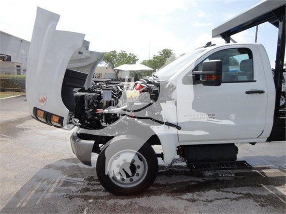 2023 Chevrolet Silverado 5500HD cab-forward utility truck with hood open, showing front engine bay and hydraulic system components.
