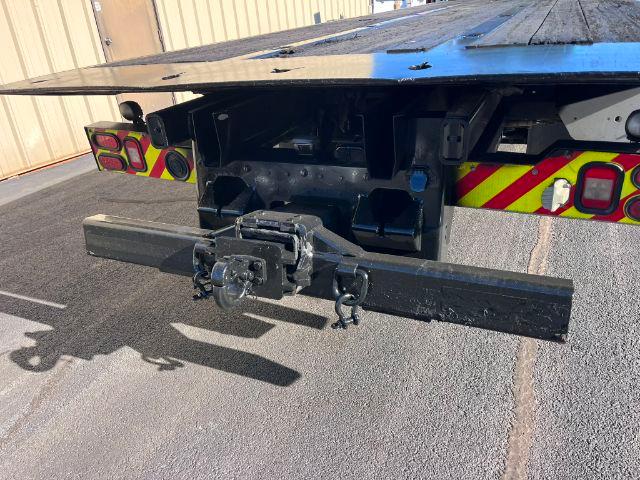 Rear view of a 2016 Freightliner M2 106 rollback truck showing tow hitch, bumper, and chassis with reflective chevrons.