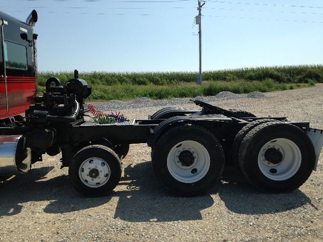 Kenworth T800 chassis with third axle and dual rear wheels showing fuel lines and fifth wheel area.