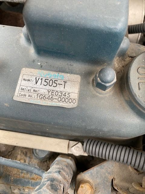 Truck lift component with a label showing Model V1505-T, EEO345, and Serial No. 06646-700000; gray-blue metal surface with bolt and wiring harness.
