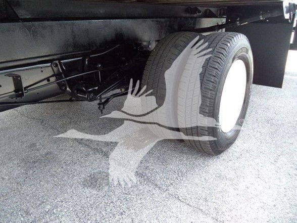 Rear wheel and undercarriage of a Ford E-450 box truck showing twin rear tires, chassis, and suspension components.