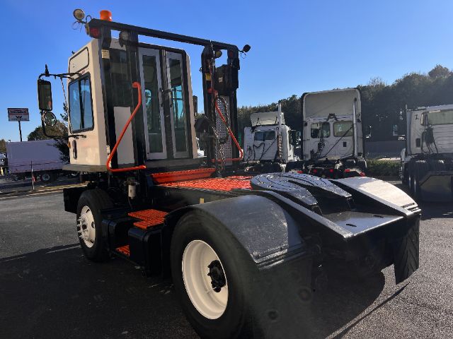 Truck yard showing a white and black 2013 Tico PROSPOTTER DOT yard truck with bright orange steps and protective rails.