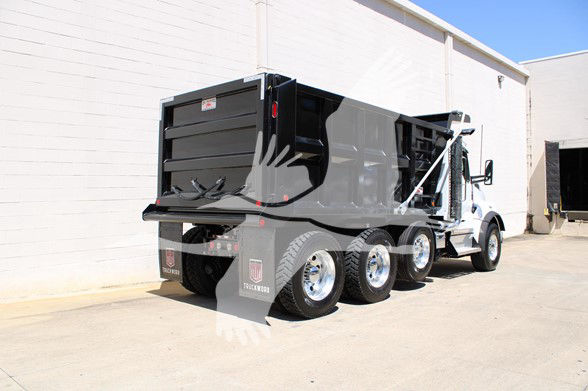 Kenworth T880 dump truck rear and side view showing black dump body and triple rear axles.