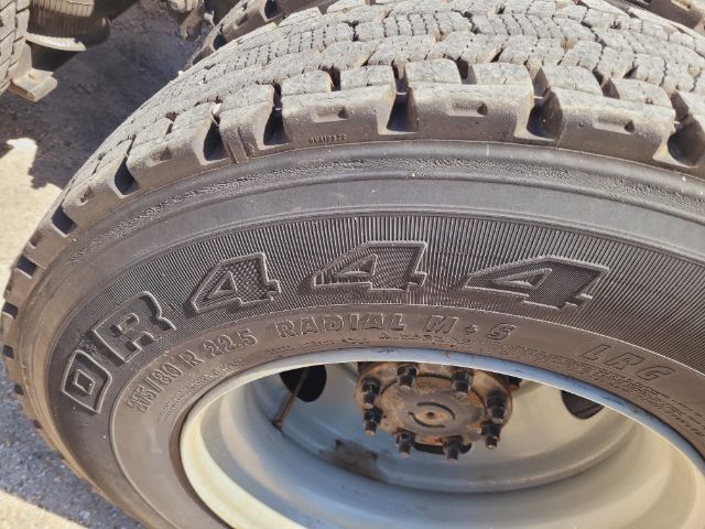 Volvo VNR Daycab wheel and tire with large 'R 4 4 4' style markings; tire tread visible; sidewall shows 'RADIAL M+S' and other small text.