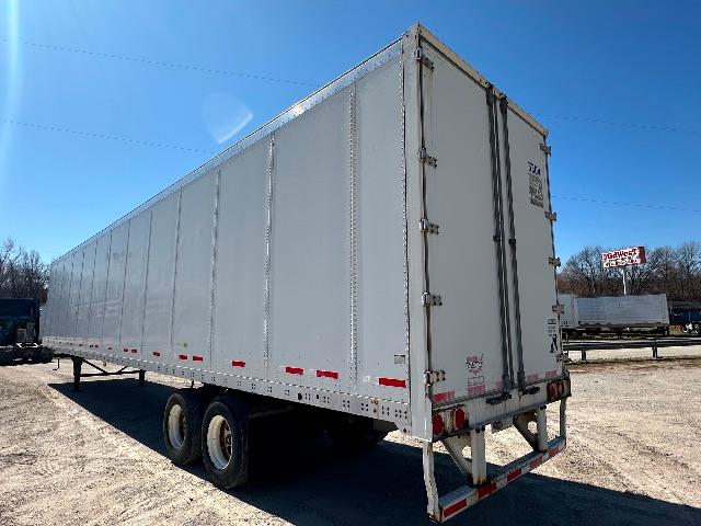 2015 Wabash DuraPlate dry van trailer side and rear showing tandem axles and closed doors with reflective tape.