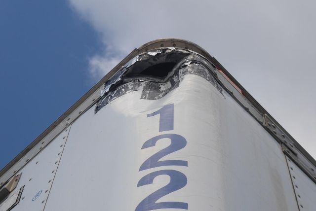 Trailer nose with damaged top cap and the number 1221 vertically along the front edge.