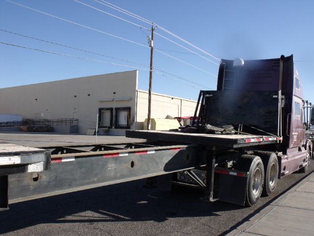 Semi truck with 48 to 80 foot expandable flatbed trailer showing extended deck and hydraulic system.