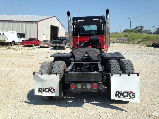 Back view of a Kenworth truck with dual rear axles, fifth wheel, and two white mud flaps labeled 'RICKS'.