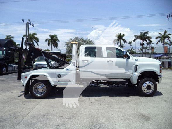 2023 International CV tow truck side view showing front cab and hydraulic tilt bed with raised bed at the rear.