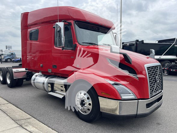 Volvo VNL64T740 truck in red with sleeper cab, chrome front bumper, side fuel tanks, dual rear axles visible.