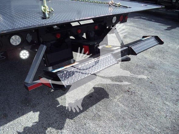 Rear view of a 2023 International CV tow truck with a dual fold-down hitch/steps and diamond plate surfaces visible on the bed.