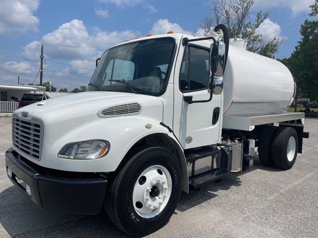Freightliner M2 sewer service truck with white tank, front grille, and dual rear wheels in driveway.