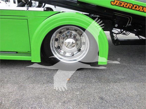 Green Peterbilt tow truck wheel well and chrome wheel visible with partial Jerr-Dan branding on the boom. Stock number J62011, VIN 2NP2HM6XXNM762011 text overlaid in listing context.