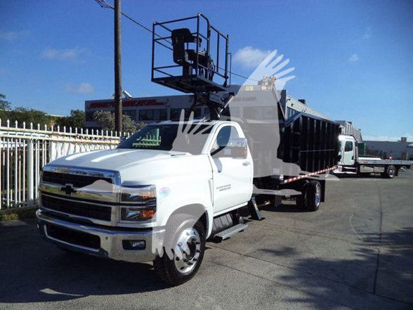 Chevrolet Silverado 6500HD dump truck on lot with tilt bed and aerial lift equipment mounted on truck