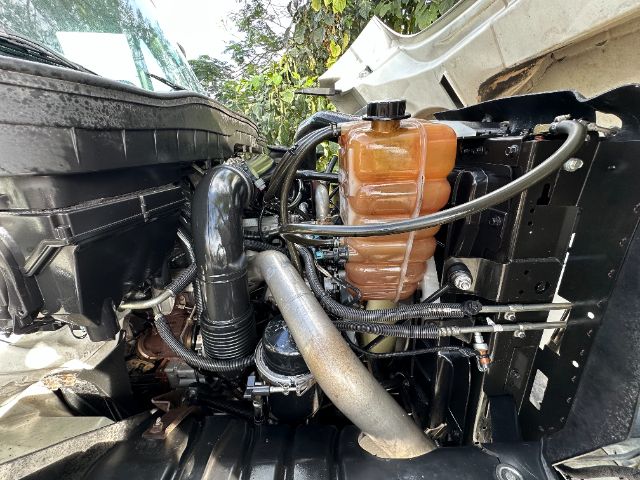 International 7500 engine bay showing coolant reservoir, various hoses, and intake components.
