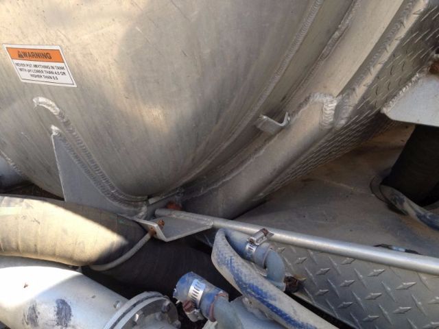 Vacuum tank on a 2008 Progress VA72 trucks showing hoses, fittings, and a diamond-plate step; warning label on tank.