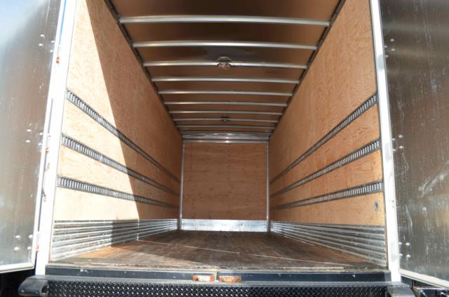 Truck box interior showing empty cargo space with wooden walls and metal rails along sides.