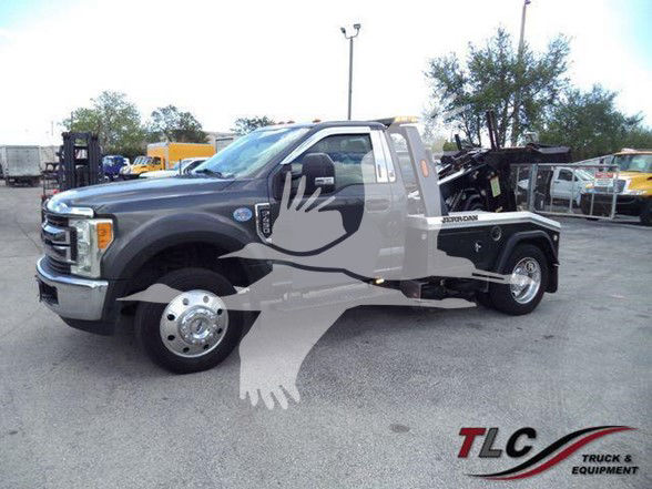 Ford F-450 tow truck in gray with flatbed, side view showing dually rear wheels and tow equipment.