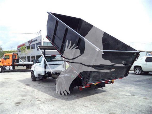 2023 Chevrolet Silverado 6500HD dump bed truck in a dealership lot with elevated bed.